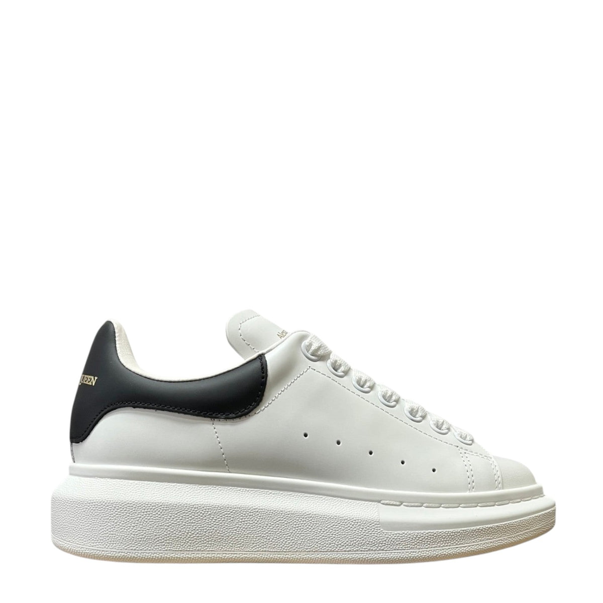 Luxury Chef Alexander McQueen white leather sneakers with black heel tab and chunky white sole.